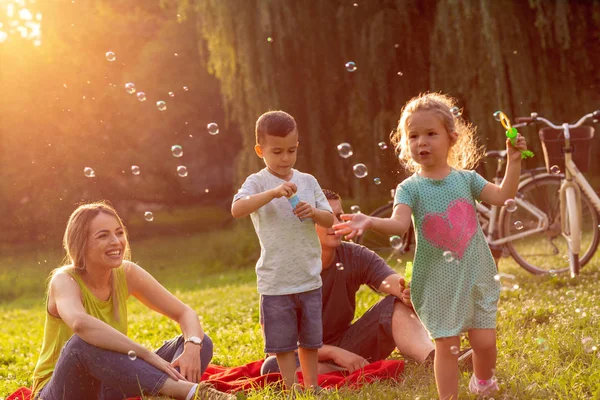 Famiglia Felice Con Bambini Piccoli Soffiano Bolle Sapone Nel Parco — Foto Stock