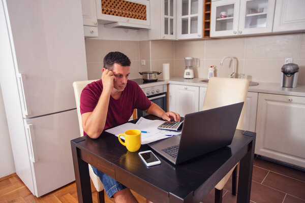 stressed man doing account about expenses at home, family budget and finances, calculate their bills, planning budget