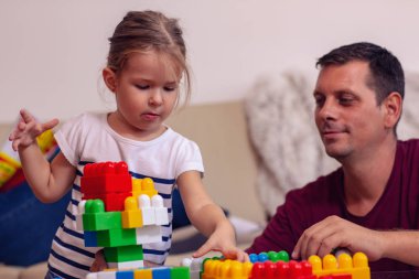 Mutlu aile - gülümseyen baba ve küpleri ile birlikte evde oynarken küçük şirin kız