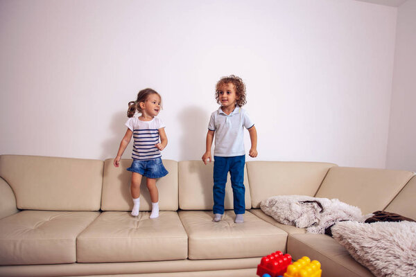 Happy children play and have fun jumping on the bed