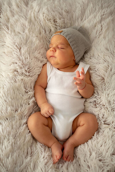 Baby boy kid infant sleeping in hat on fluffy blanket