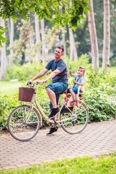 Dad and son riding bicycles outdoors together