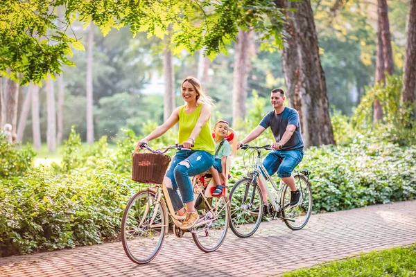 Happy family is riding bikes outdoors and smiling