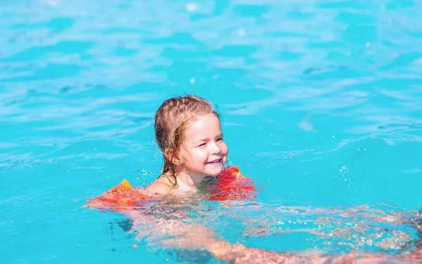 Young child is swimming in a pool -Cute kid swimming in the pool — Stock Photo, Image