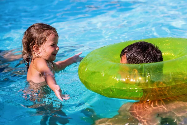 Glückliche Familie spielt im Schwimmbad. Sommerferien — Stockfoto