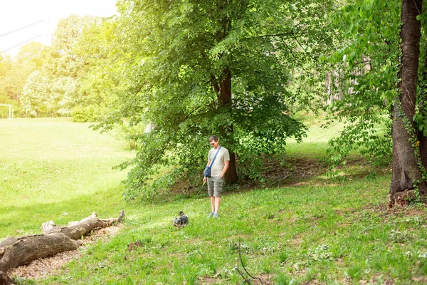 Muž se psem užívajícím v parku — Stock fotografie