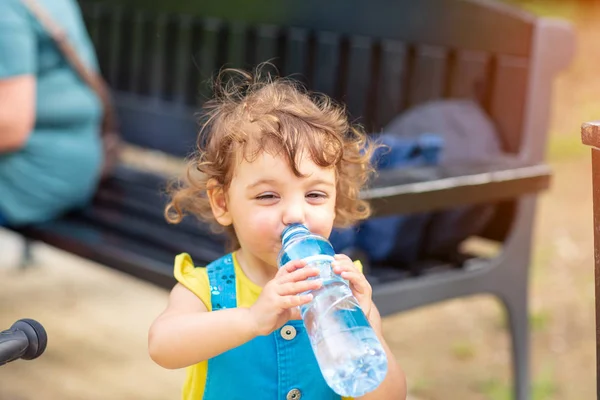 Kleines Mädchen trinkt Wasser aus der Flasche — Stockfoto