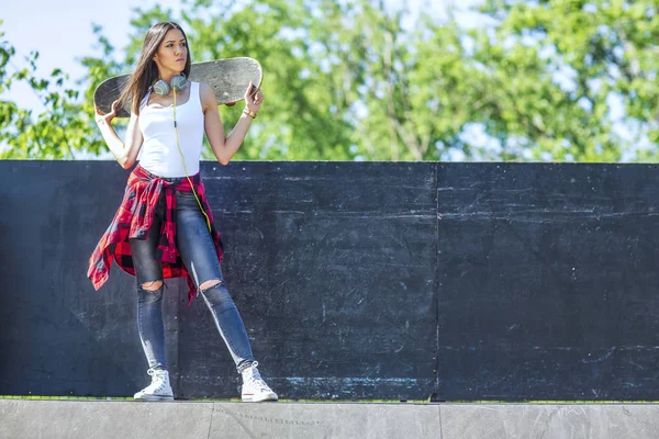 Ung kvinna anläggning skateboard — Stockfoto