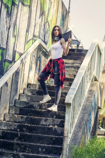 Ung flicka som håller skateboard utomhus, urban livsstil — Stockfoto
