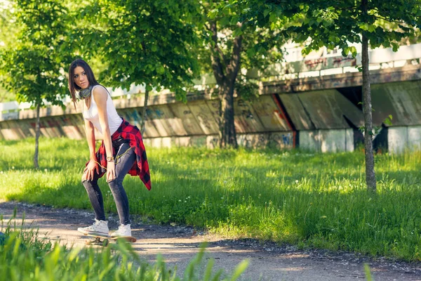 Sportowa Dziewczyna jazda deskorolki na ulicy — Zdjęcie stockowe