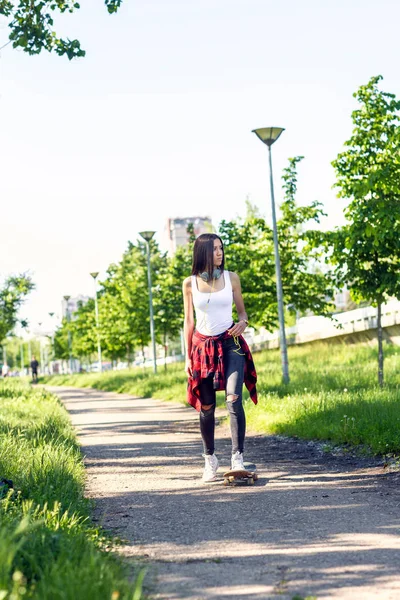 Leende flicka ridning skateboards på City Street — Stockfoto