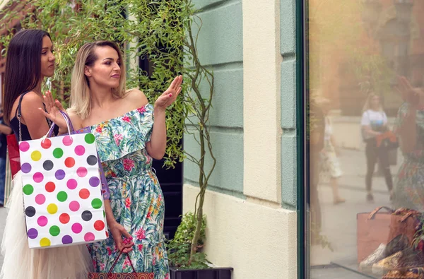 Mulheres em compras olhando para vitrine na cidade — Fotografia de Stock