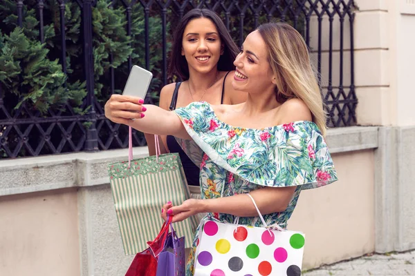 Dwie dziewczyny w zakupie na dzień zakupów i wziąć selfie z telefonem komórkowym — Zdjęcie stockowe