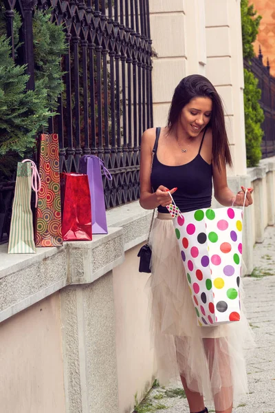 Uśmiechnięta kobieta z torby na zakupy kupił ubrania i buty — Zdjęcie stockowe
