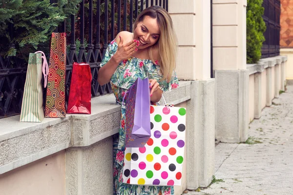 Happy Shopping-kobieta trzyma torby na zakupy i uśmiechnięty stojąc na zewnątrz — Zdjęcie stockowe