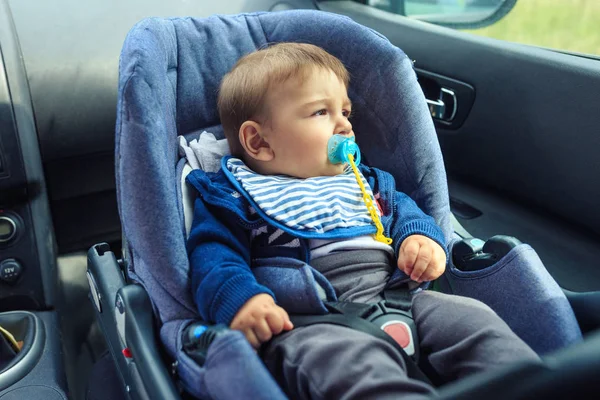 Детское автокресло для безопасности. Счастливый мальчик, сидящий в машине в кресле безопасности . — стоковое фото