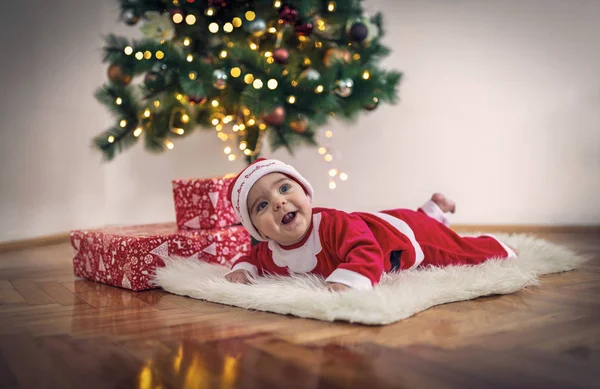 Noel Baba kostümlü gülümseyen bebek noel odasında. — Stok fotoğraf