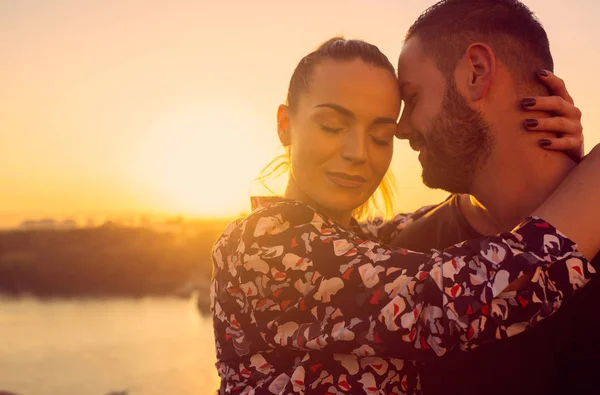 Romantyczna para całuje się na świeżym powietrzu o zachodzie słońca Obraz Stockowy