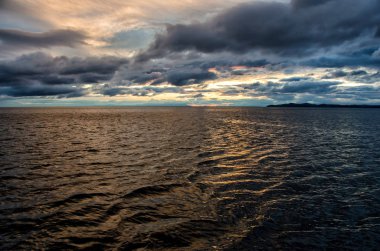 Fırtınalı bulutlar dramatik gökyüzü moody koyu ve başgösteren yansıtan su genelinde üzerinden günbatımı