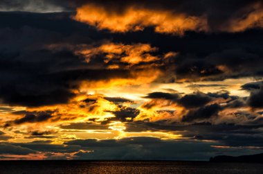 Günbatımı yalıtım deniz tehlike ve önsezim iklim değişikliği hava bulutlu ve gri, koyu ve başgösteren dramatik gökyüzü huysuz duygu yansıtan su genelinde fırtınalı bulutlar üzerinde.