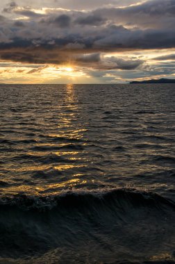 Fırtınalı bulutlar dramatik gökyüzü moody koyu ve başgösteren yansıtan su genelinde üzerinden günbatımı