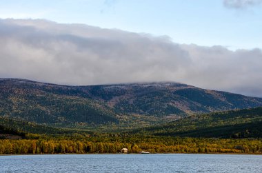 Sunrise - tasarımınız için pastel renklerde bulutlu gökyüzü dağlar manzaraya. Romantik deniz manzarası - silhouettes bir siste blue Hills deniz manzaralı.
