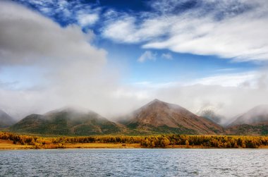Dağlar peyzaj - tasarımınız için pastel renklerde bulutlu gökyüzü. Romantik deniz manzarası - siluet sis ve sonbahar ormandaki blue Hills deniz manzaralı