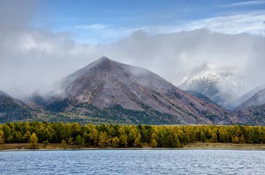 Dağlar peyzaj - tasarımınız için pastel renklerde bulutlu gökyüzü. Romantik deniz manzarası - siluetleri blue Hills ormandaki bir sis ve sonbahar, Baykal Gölü manzaralı sahil