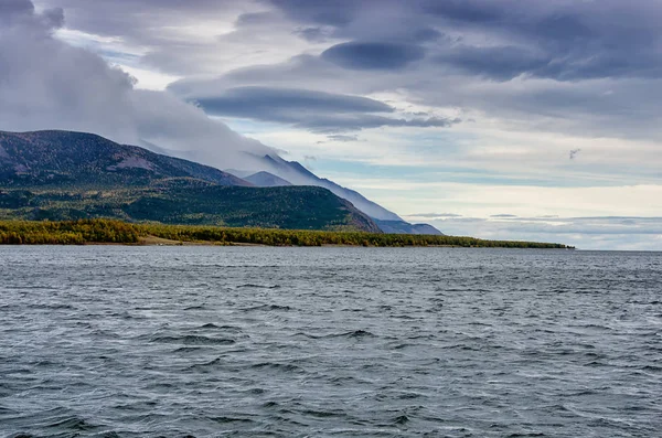 Landskap - molnig himmel i pastellfärger för din design. Romantiska seascape - havet med silhuetter av blue hills i en dimma och falla skog — Stockfoto