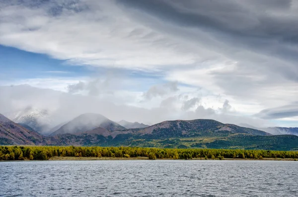 Paesaggio di montagne - cielo nuvoloso in colori pastello per il Suo progetto. Romantico paesaggio marino - vista sul mare con sagome di colline blu in una nebbia e foresta autunnale — Foto Stock