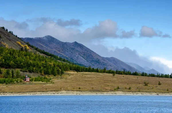 Landskap - molnig himmel i pastellfärger för din design. Romantiska seascape - havet med silhuetter av blue hills i en dimma och falla skog — Stockfoto