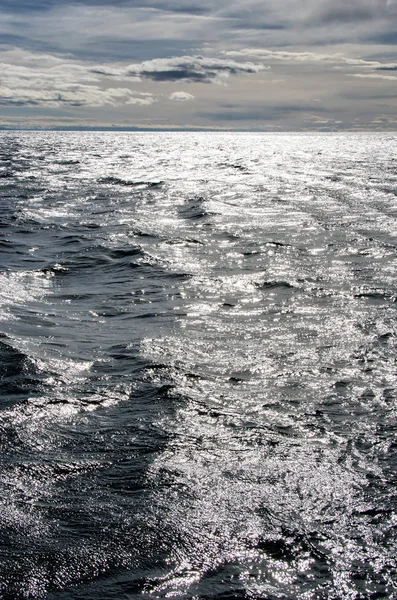 Blauwe zonnige zee en bewolkte blauwe hemel — Stockfoto