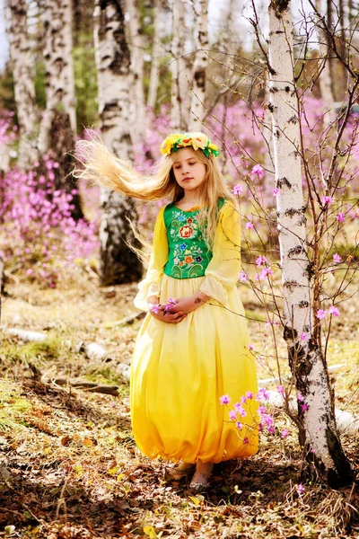 Un niño está de pie entre el ledum y el abedul en vestido verde amarillo, sonriendo y con el pelo mojado — Foto de Stock
