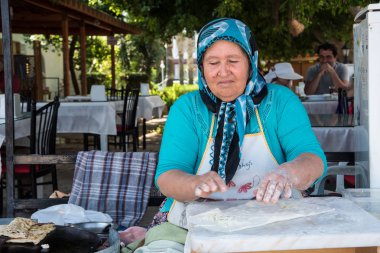 Mersin, Türkiye - 14 Haziran 2018: geleneksel Türk mayasız ekmek gezleme hazırlanıyor bir eldery Türk kadını. Türk mutfağı pide çoğu yemekleri ile kullanımı içerir