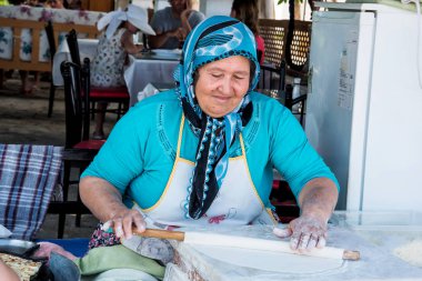 Mersin, Türkiye - 14 Haziran 2018: geleneksel Türk mayasız ekmek gezleme hazırlanıyor bir eldery Türk kadını. Türk mutfağı pide çoğu yemekleri ile kullanımı içerir