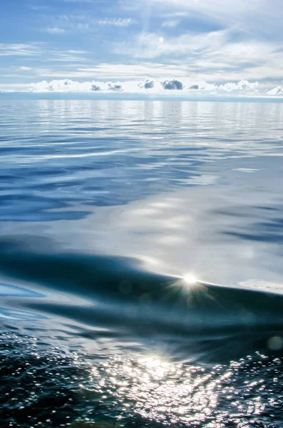 Sonnenlicht funkelt und spiegelt das Wasser des Sees. Hintergrund mit Sterneffekt — Stockfoto
