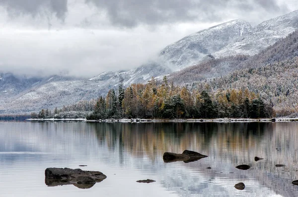 Lago di montagna Froliha, pino e sassi con neve al lago specchio — Foto Stock