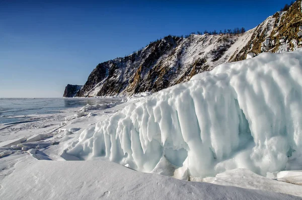 Jezero Bajkal je pokryta ledem a sněhem, silný studený, tlusté jasné modré LED. Rampouch viset ze skal. Jezero Bajkal je mrazivý zimní den. Úžasné místo — Stock fotografie