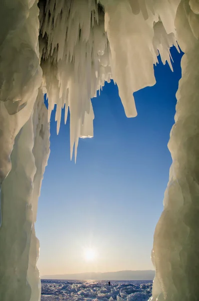 Long blue icicles in the ice cave at coastal cliffs. — Stock Photo, Image