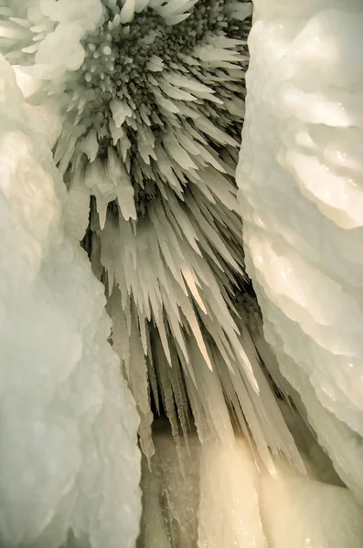 Fondo de estalactitas de hielo con una grieta. Carámbanos blancos en una pared de hielo congelada . — Foto de Stock