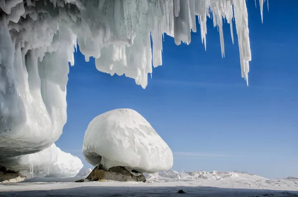 Cueva de hielo azul blanco con estalactitas de carámbano, cielo azul y hielo cubierto de piedra —  Fotos de Stock