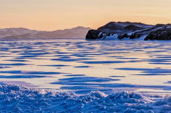 Vista del hielo y el sol naciente sobre las montañas, el lago Baikal —  Fotos de Stock