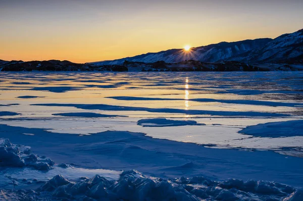 View of the ice and the rising sun over the mountains, lake Baikal — Stock Photo, Image