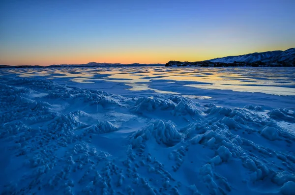 Vista del hielo y el sol naciente sobre las montañas, el lago Baikal —  Fotos de Stock