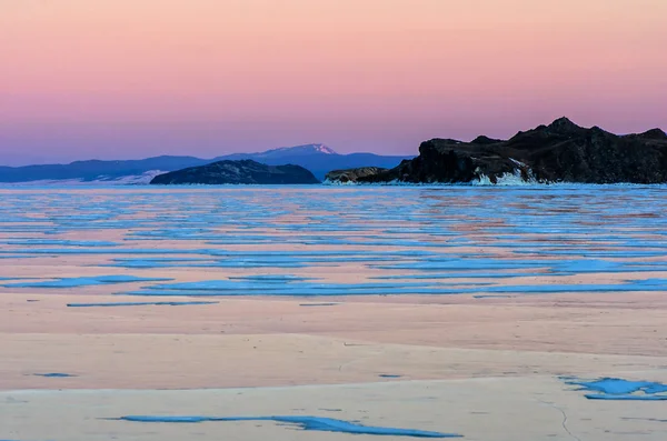 在粉红色的日落天空和山脉的贝加尔湖的蓝色冰 — 图库照片