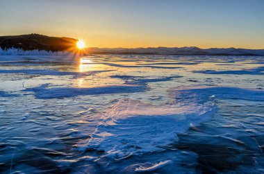 Buz ve yükselen güneşin dağların, Baykal Gölü üzerinden Amazimg portakal görünümü