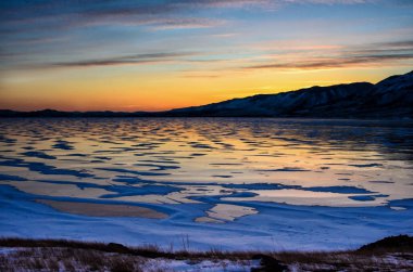 Buz ve yükselen güneşin dağların, Baykal Gölü üzerinden Amazimg portakal görünümü