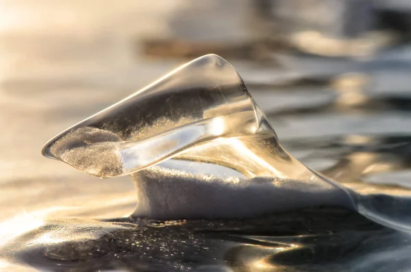 Témpano de hielo en la superficie congelada del lago con reflejo. Grietas profundas en el hielo y el reflejo del hielo —  Fotos de Stock