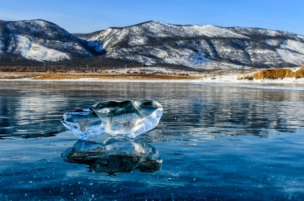 Témpano de hielo en la superficie congelada del lago con reflejo. Grietas profundas en el hielo y el reflejo del hielo —  Fotos de Stock