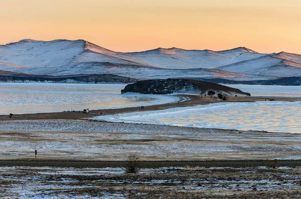 在贝加尔湖的夕阳下, 有美丽的冬冻湖和雪山。全景 — 图库照片